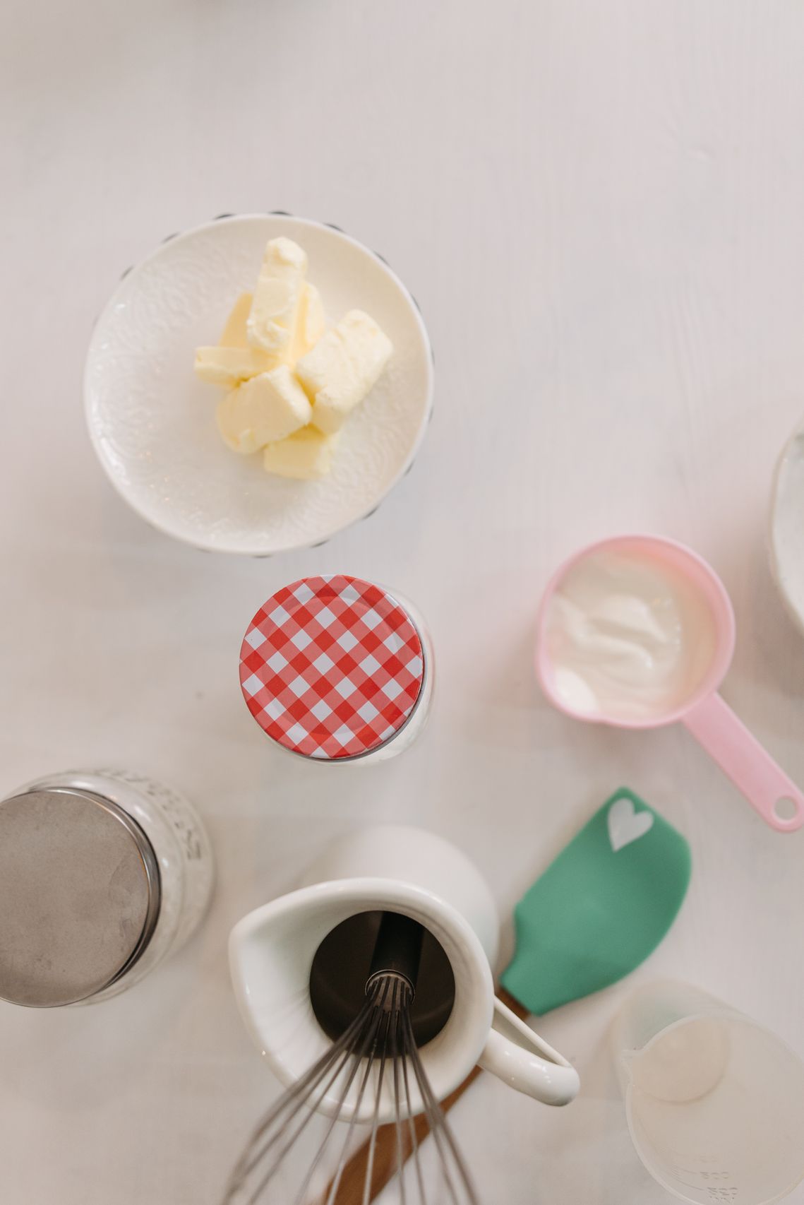 Whisk in pink cup and bowl of flour